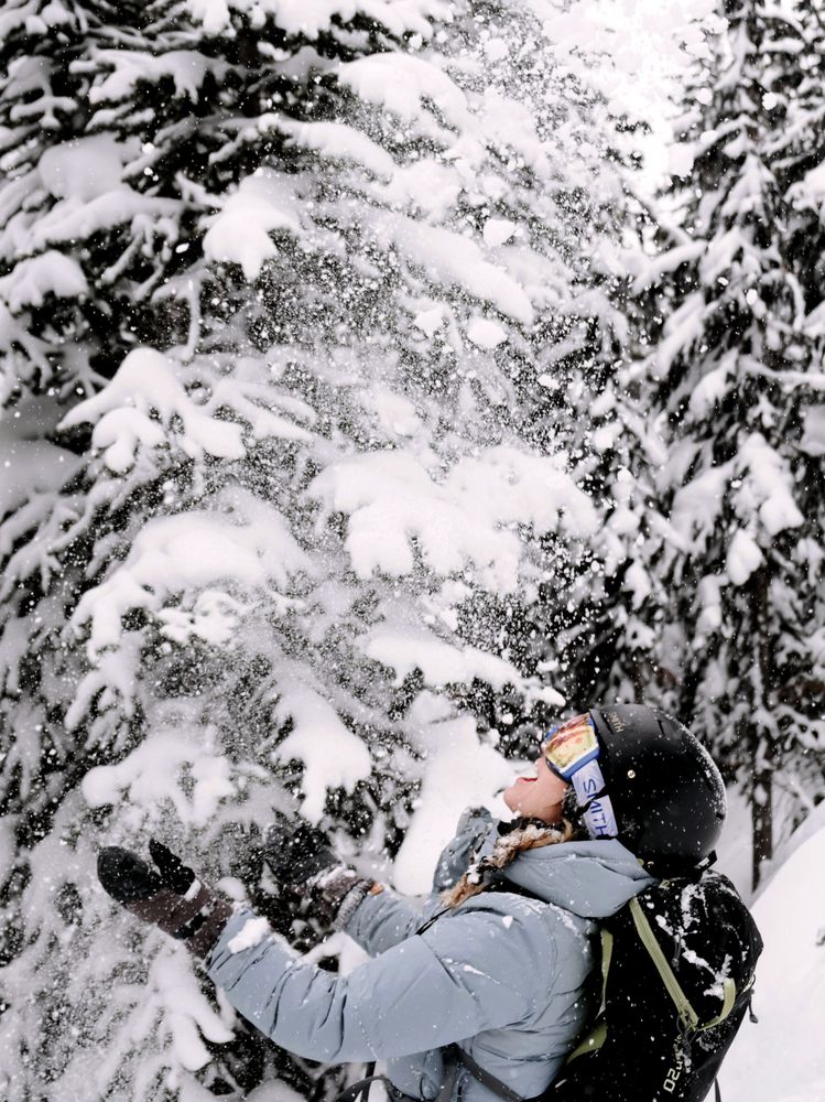 Woman wearing warm clothes extending hands to catch snow